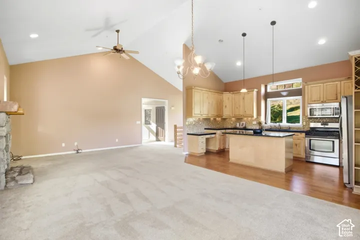 Vaulted ceiling with a ceiling fan and recessed lighting
