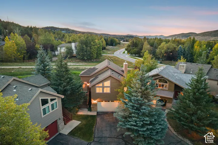 Multi-level residence featuring a prominent gable roofline and a combination of siding and stone exterior finishes