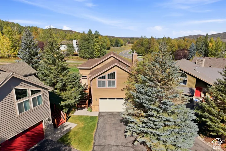 Multi-story residence featuring horizontal siding, an attached garage, and a peaked roofline