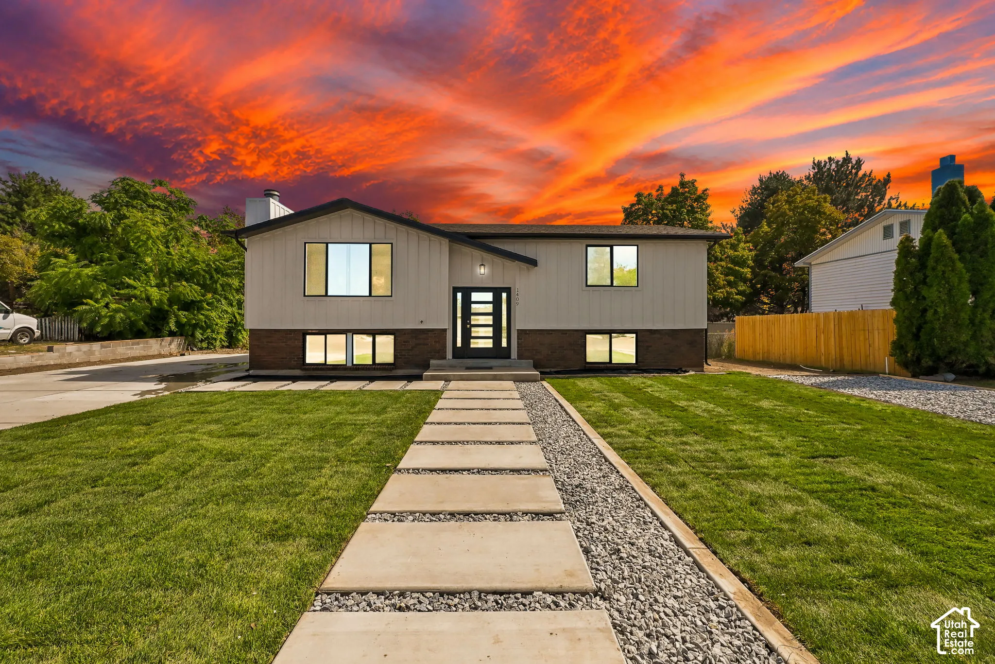 Contemporary-style residence with dark trim windows, a modern entry door, and a concrete paver walkway