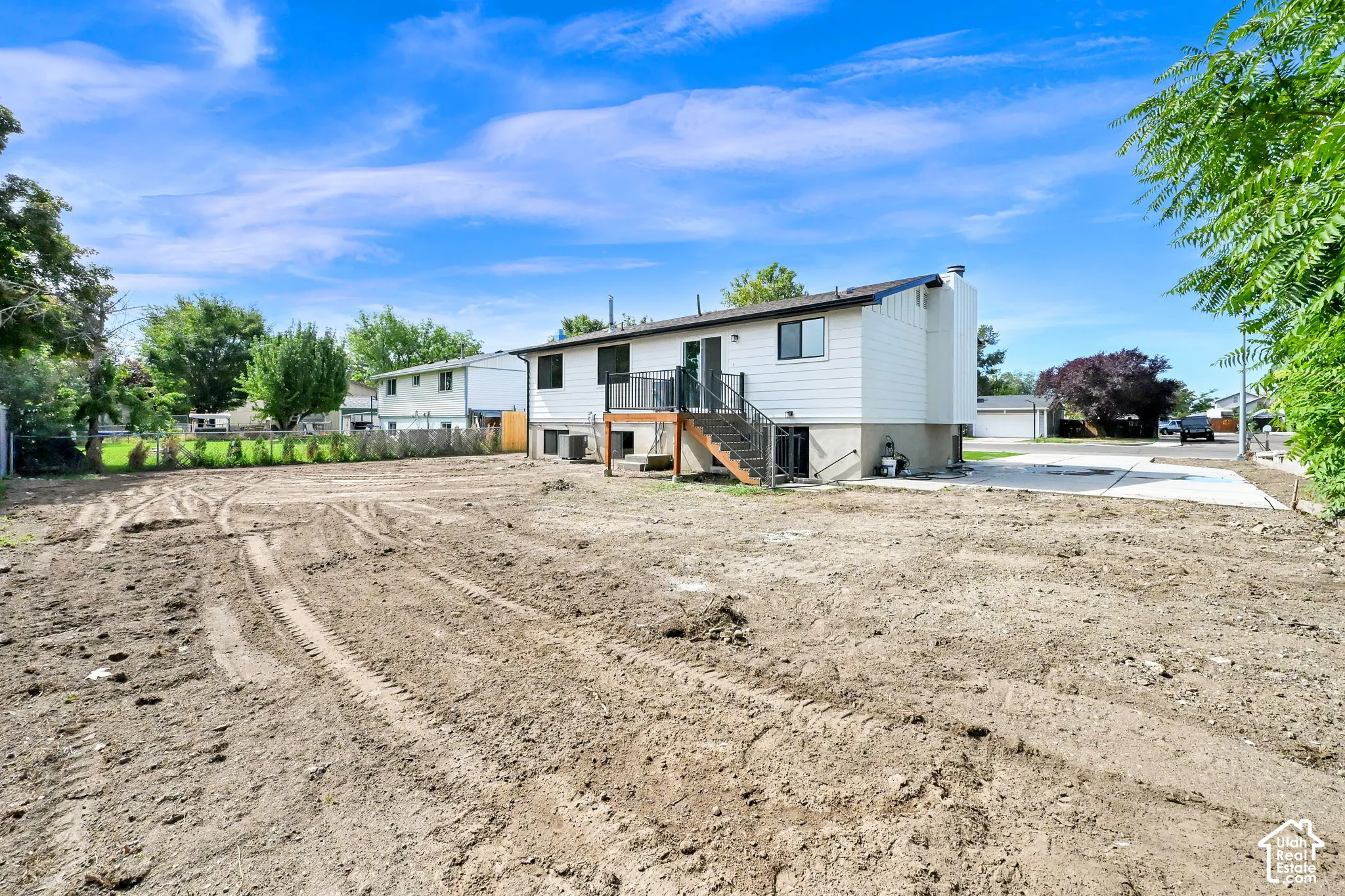Expansive graded lot with a concrete driveway, providing a blank canvas for customization