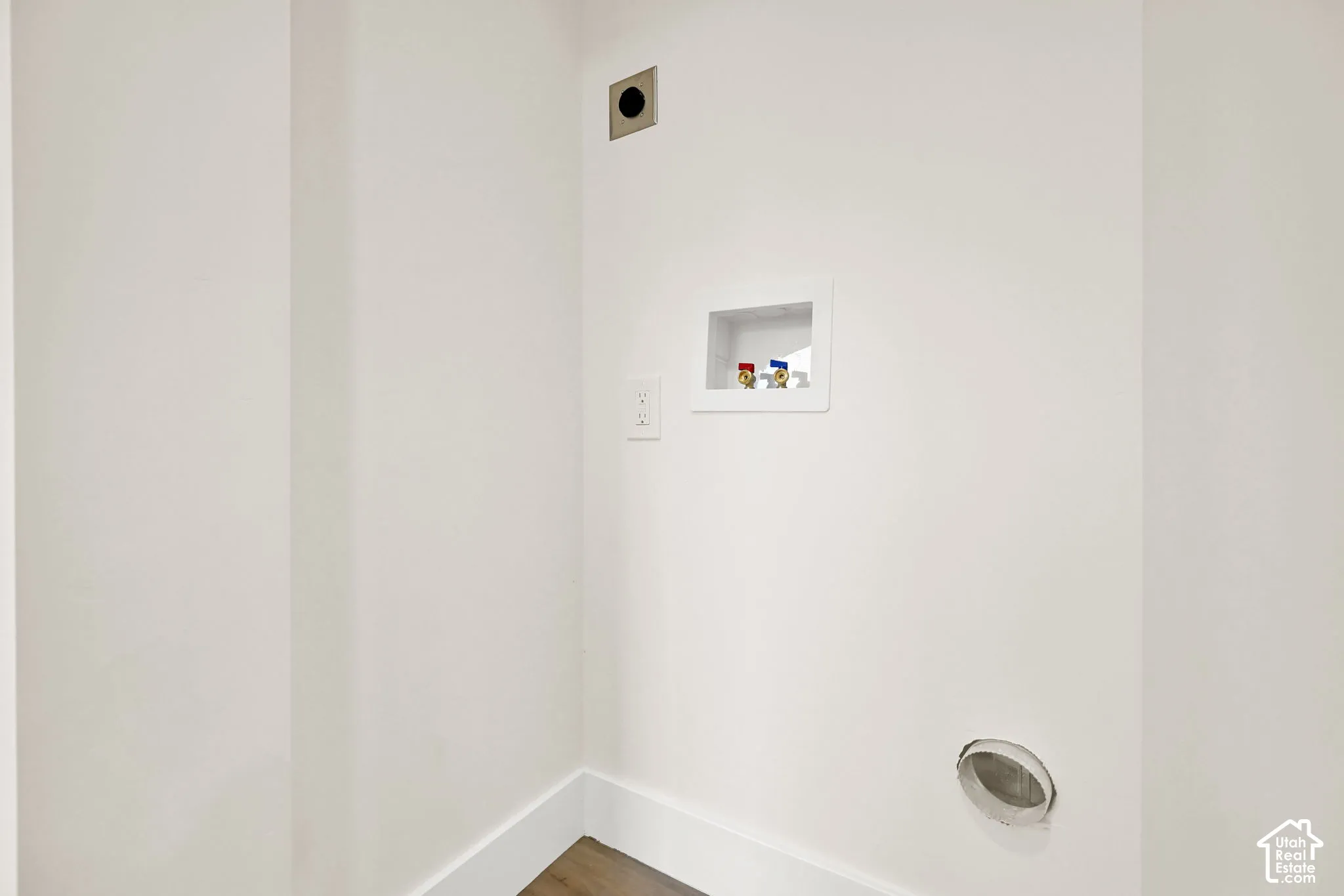 Laundry hookups featuring a dryer vent, utility box, and wall outlet