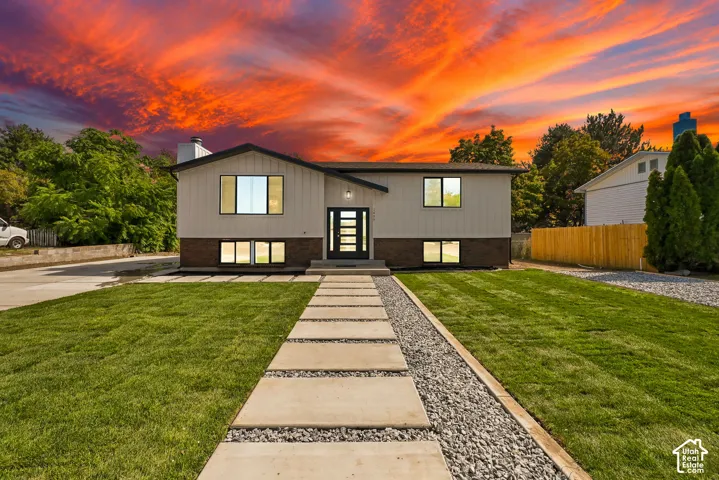 Contemporary-style residence with dark trim windows, a modern entry door, and a concrete paver walkway
