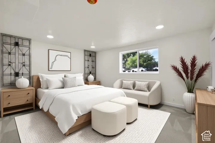 Recessed lighting illuminates the space, featuring a window with exterior views and wood-finish flooring
