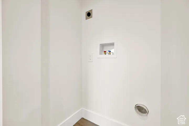 Laundry hookups featuring a dryer vent, utility box, and wall outlet