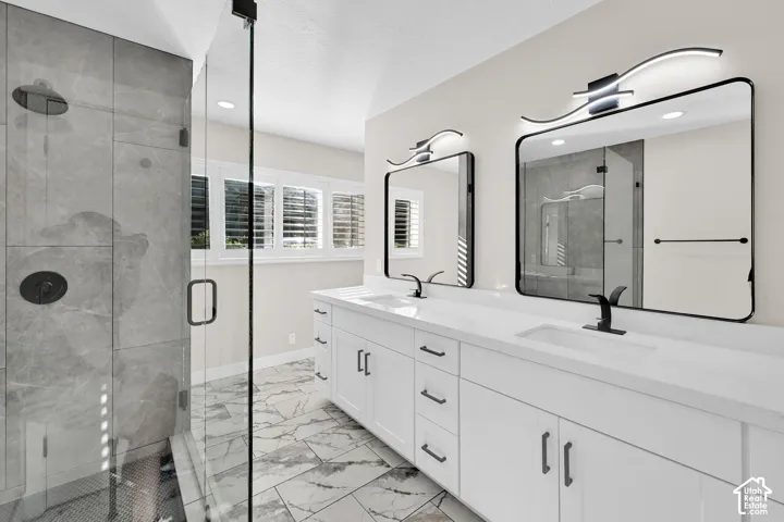 Dual vanity with white cabinetry, matte black fixtures, and framed mirrors