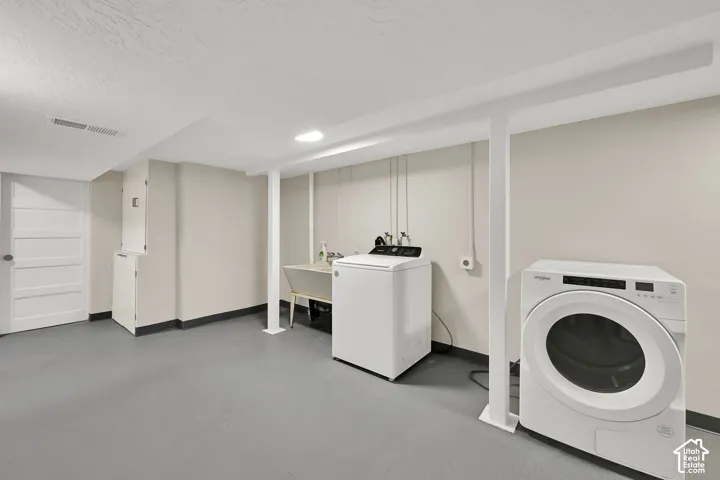 Laundry area featuring a washbasin, light-toned walls, and a recessed ceiling light