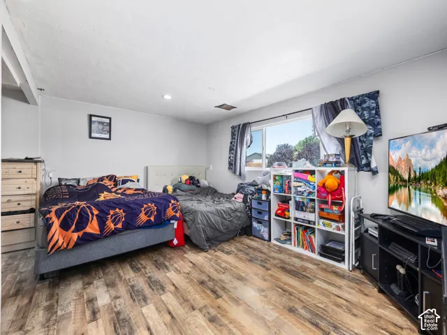 Wood-finish flooring, light gray walls, and a recessed ceiling light