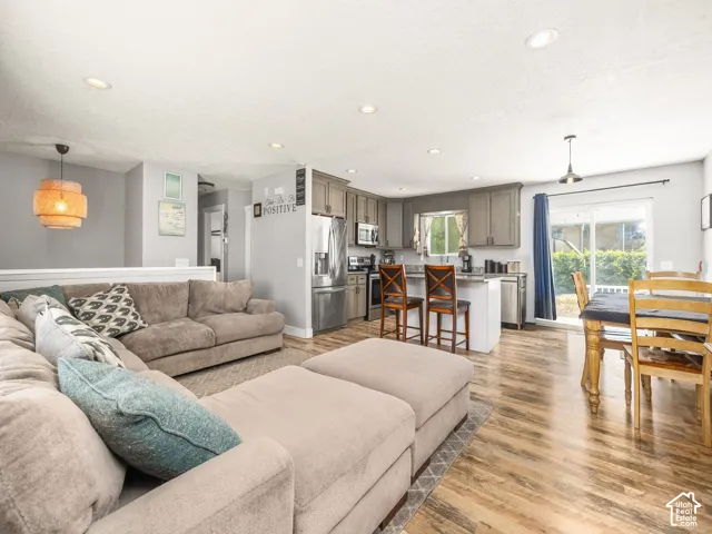 Open-concept living area featuring wood-finish flooring, recessed lighting, and a white half-wall partition