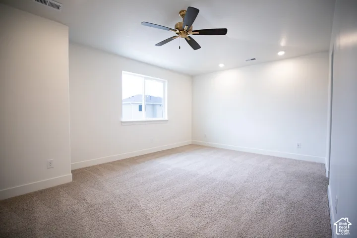 Primary bedroom featuring a ceiling fan and a vaulted ceiling