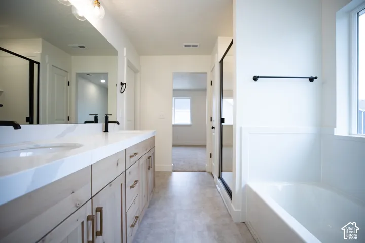 Primary bathroom featuring dual vanity and separate tub and shower