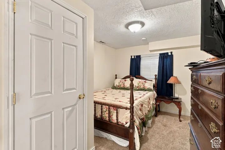 Carpeted room with a ceiling-mounted light fixture and a window with blinds