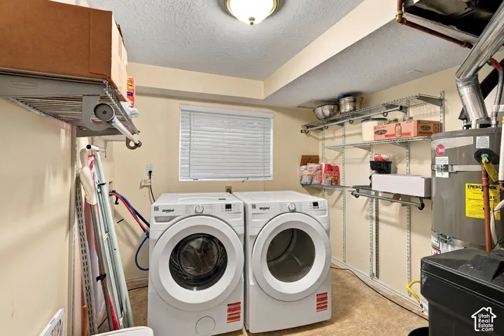 Window-equipped utility space featuring a built-in water heater, wall-mounted wire shelving, and a durable flooring surface