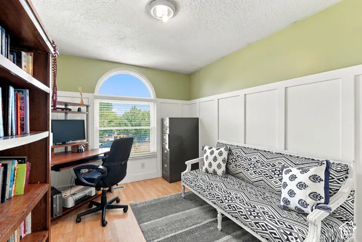 Wood-finish flooring complemented by a decorative wall paneling accent wall