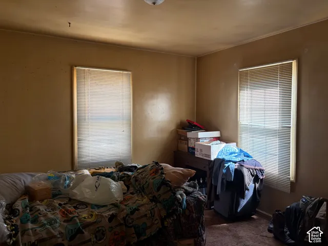 Room featuring two windows with horizontal blinds and a flush mount ceiling light