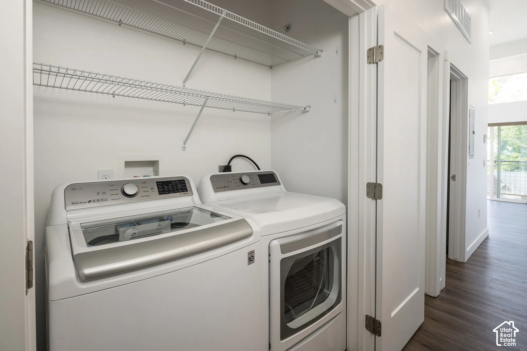 Laundry closet with white wire shelving, wood-finish flooring, and white interior doors