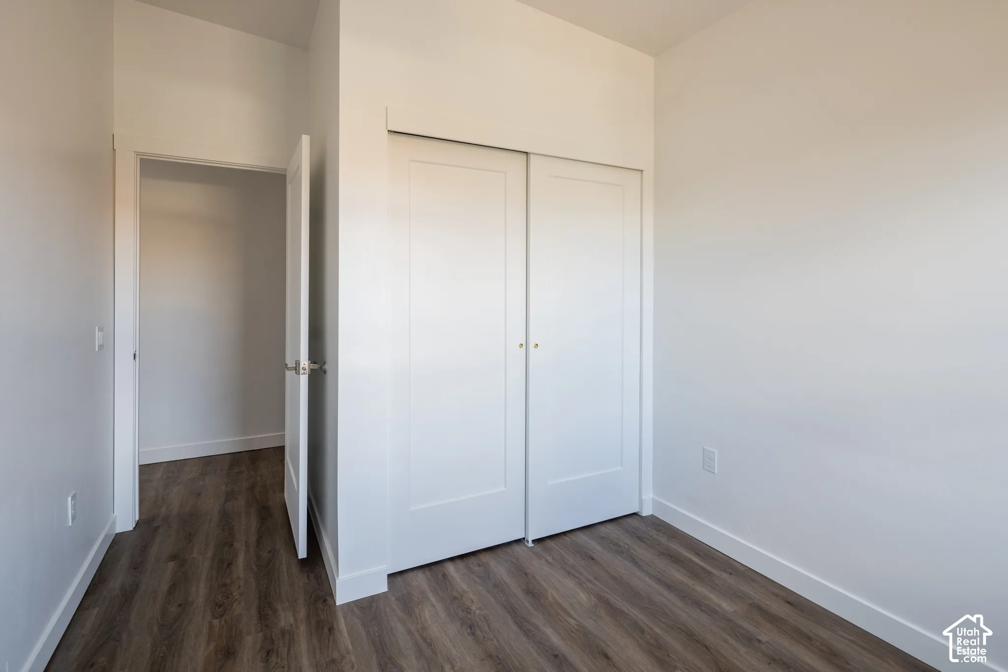 Wood-finish flooring, white walls, and a white sliding closet door