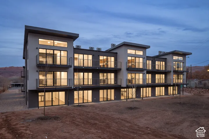 Contemporary multi-level building featuring multiple balconies with metal railings, extensive glazing, and a flat roofline