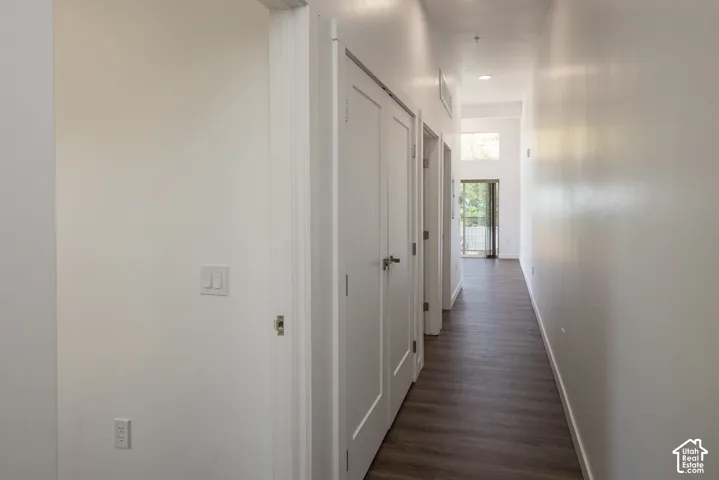 Hallway featuring wood-finish flooring, white walls, and recessed lighting
