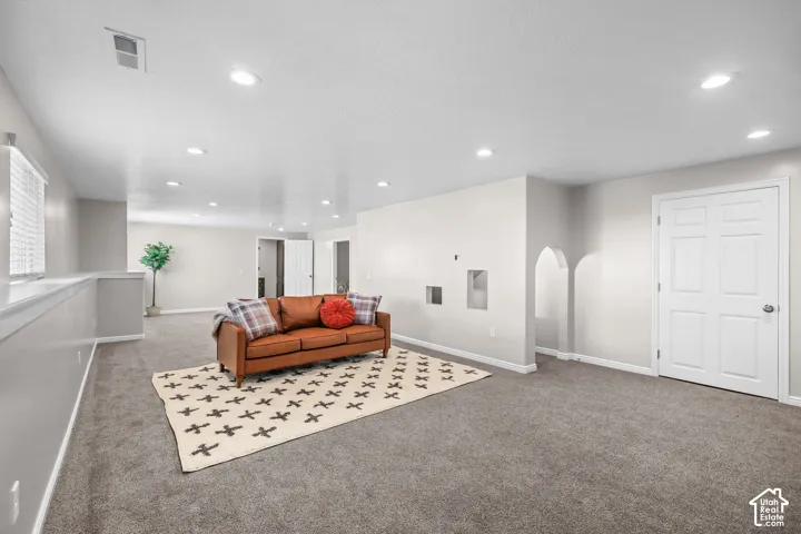 Recessed lighting, wall-to-wall carpeting, arched wall niches, and a paneled interior door