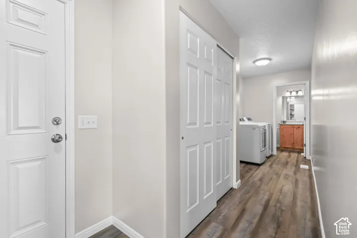 Wood-finish flooring throughout, white paneled doors, and a laundry area with appliances