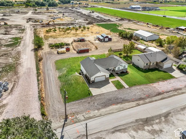 White exterior with an attached garage, paved driveway, and a front walk leading to the entry