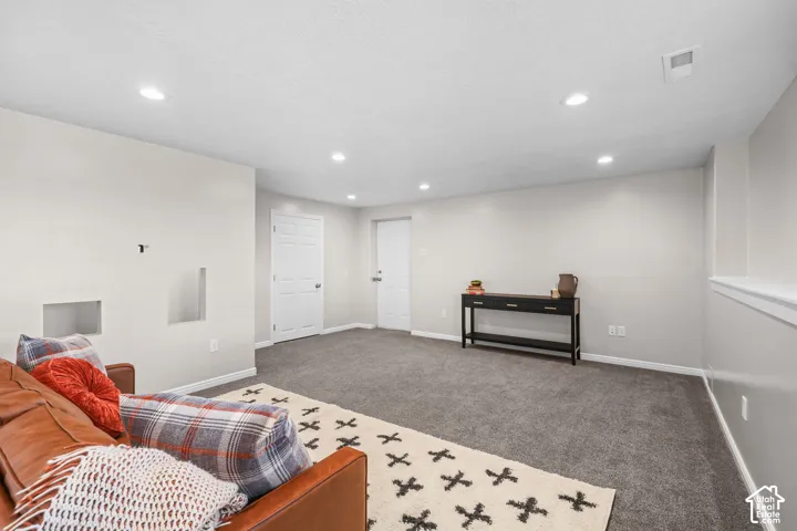 Recessed lighting, light gray wall paint, white trim, and gray carpet flooring