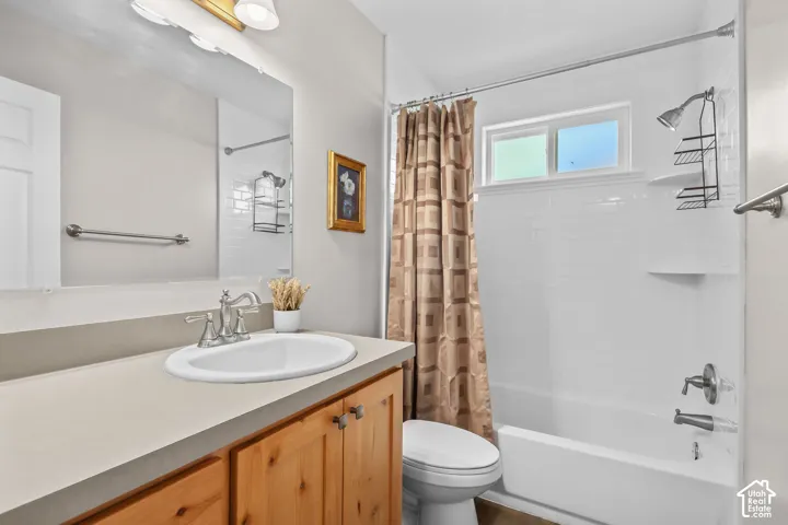 Bathroom featuring a vanity with wood-finish cabinetry, an integrated sink, and a brushed nickel faucet
