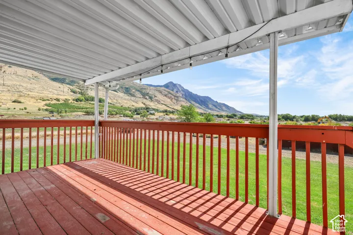 Covered exterior deck with wood-finish flooring and railing