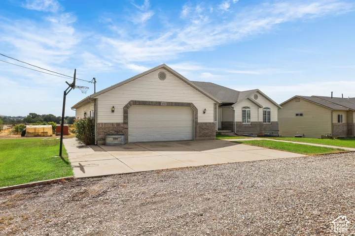 Light-toned siding exterior with a brick accent foundation and an attached two-car garage