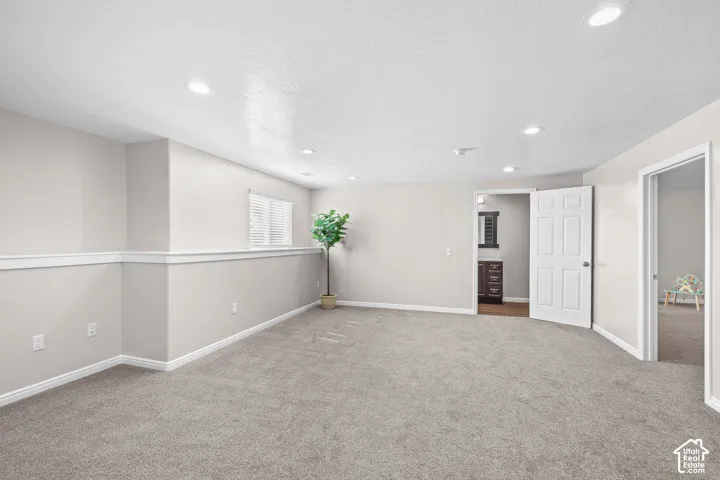 Recessed lighting, light gray carpeting, window with blinds, interior doors, and chair rail molding