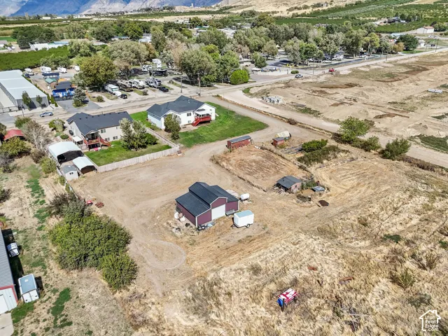 Expansive lot featuring a detached outbuilding, mature landscaping, and mountain backdrop