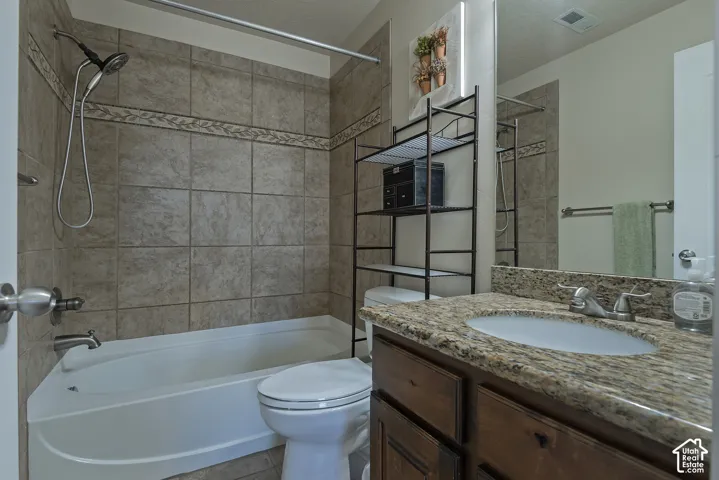 Vanity with a speckled countertop, undermount sink, and brushed nickel faucet