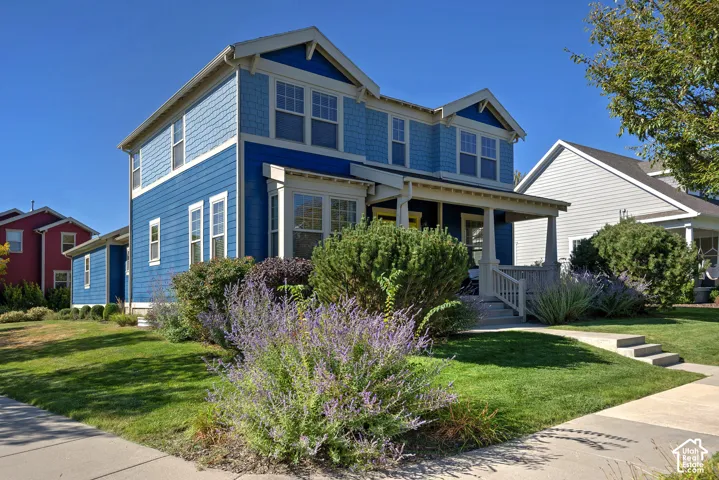 Two-story residence featuring blue siding, white trim, and a covered front porch