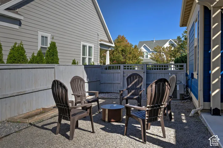 Private outdoor patio with gravel surfacing, horizontal slat fencing, and latticework accents