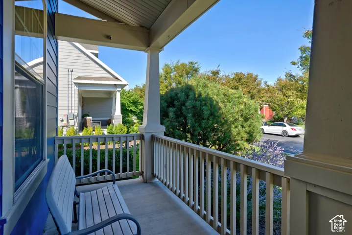 Covered porch with concrete flooring and painted wood railing