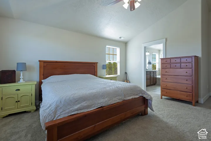 Vaulted ceiling with a ceiling fan, carpeted flooring, and a window with blinds