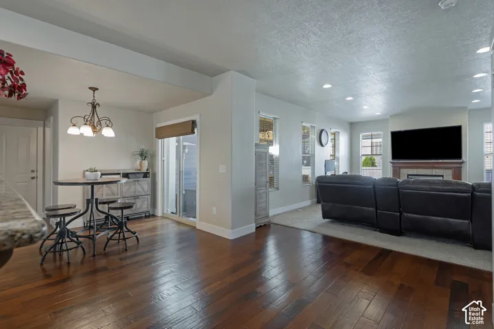 Wood-finish flooring, recessed lighting, and a fireplace with a wood mantel