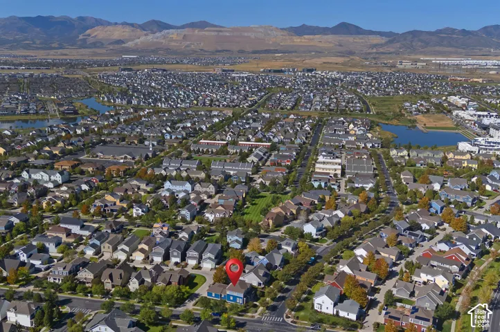 Expansive neighborhood with diverse housing styles, tree-lined streets, and multiple water features