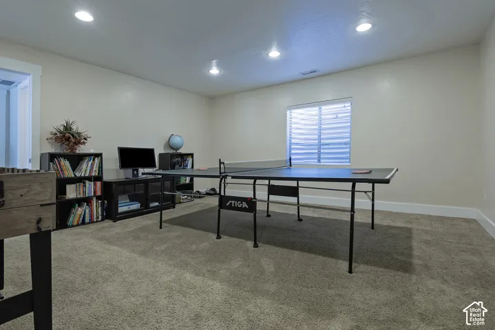 Recessed lighting illuminating a neutral-toned room with plush carpeting