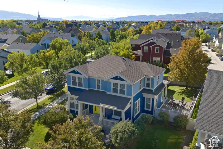Two-story residence with blue siding and white trim, featuring a covered front porch and a multi-level deck