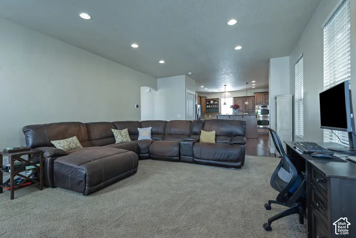 Recessed ceiling lighting, textured wall finish, window blinds, and carpeted flooring