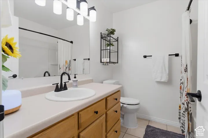 Bathroom featuring a single vanity, wood-finish cabinetry, and a black-finish faucet