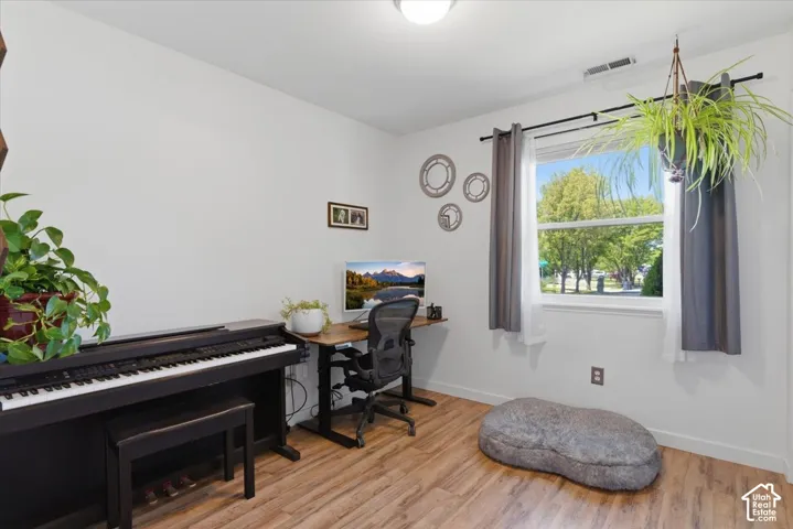 Wood-finish flooring with white walls and a large window