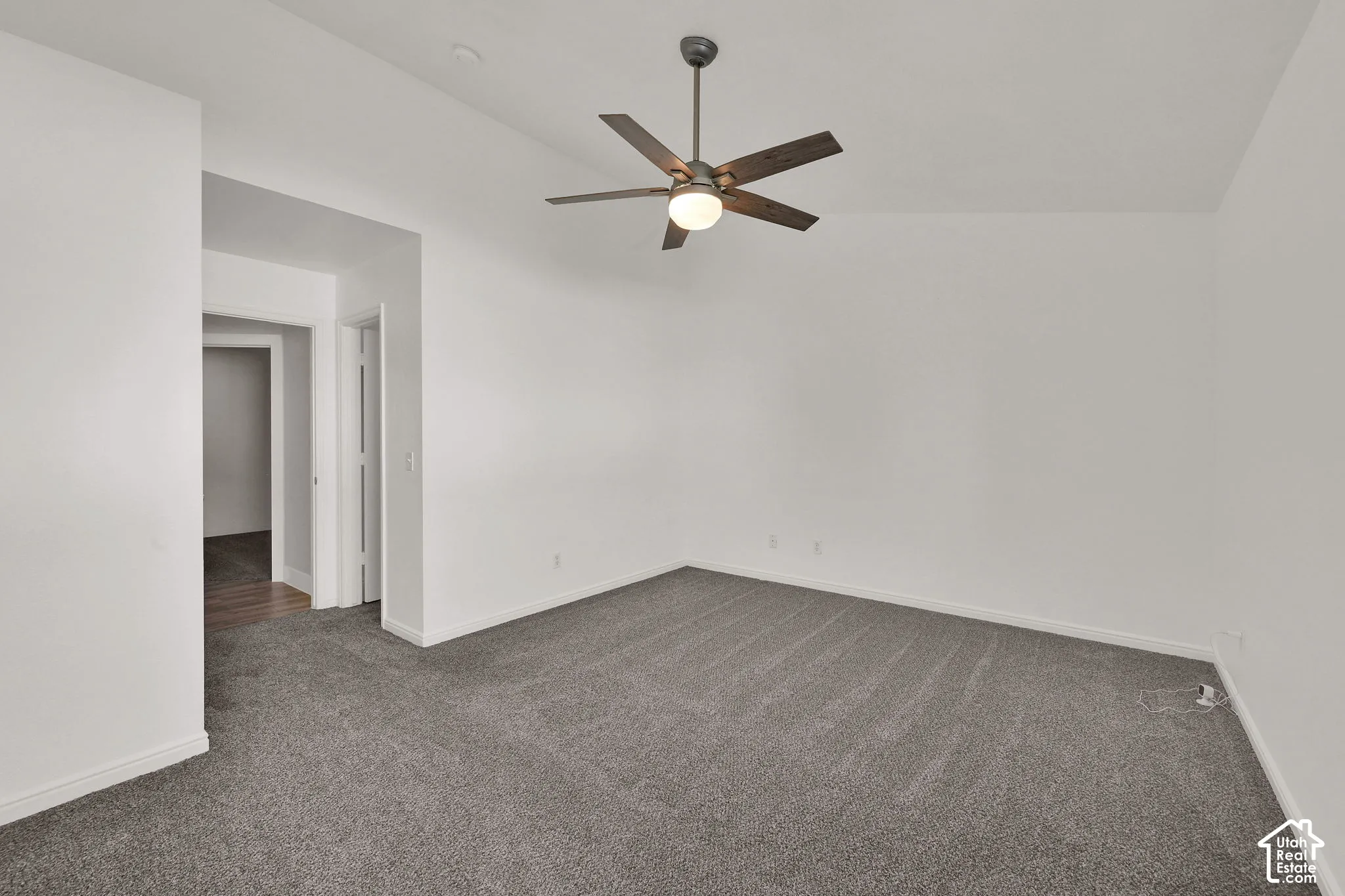 Primary Bedroom with vaulted ceiling with a ceiling fan, neutral wall paint, and gray carpeting