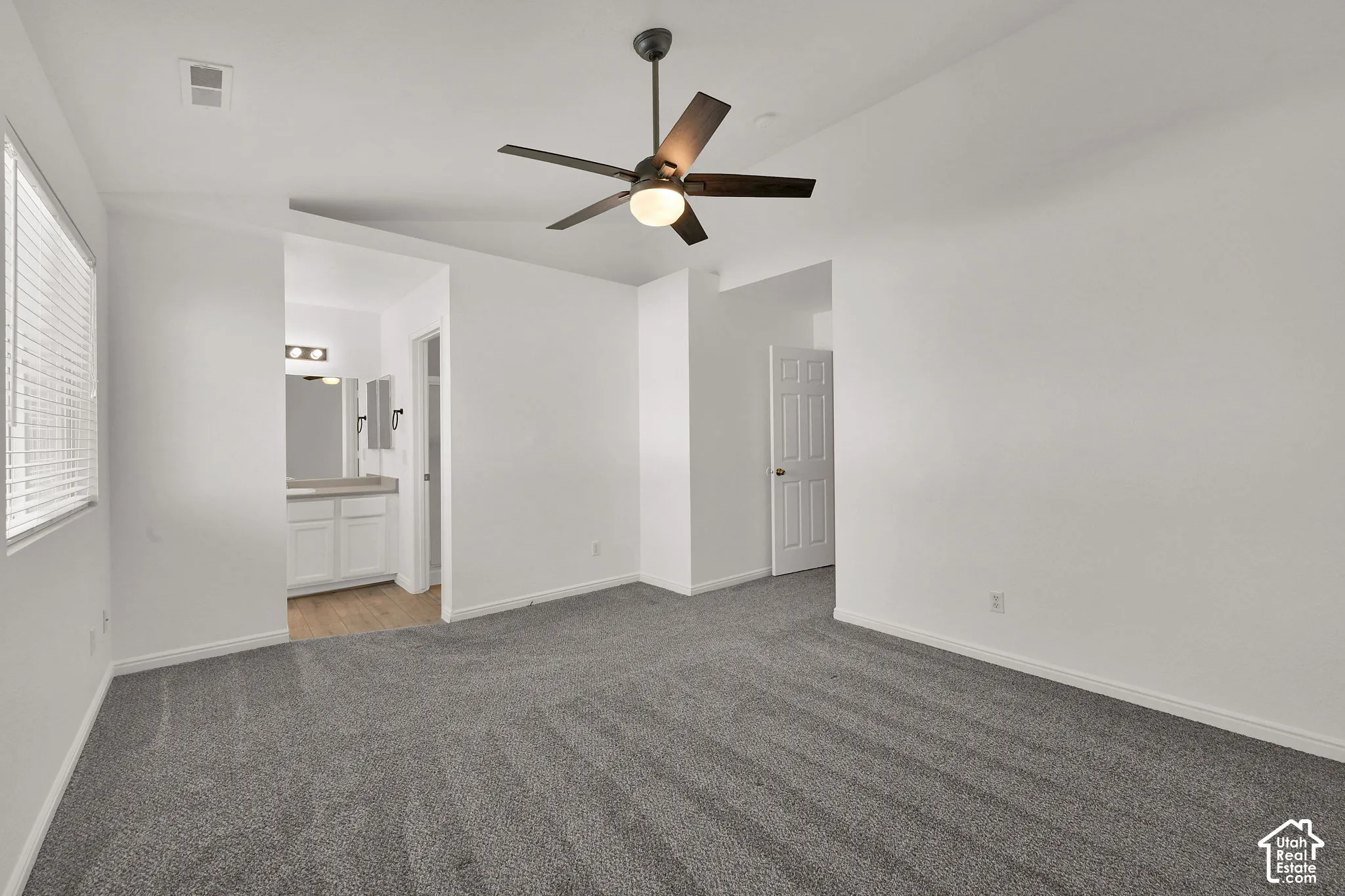 Spacious Primary Bedroom with gray carpeting and a ceiling fan