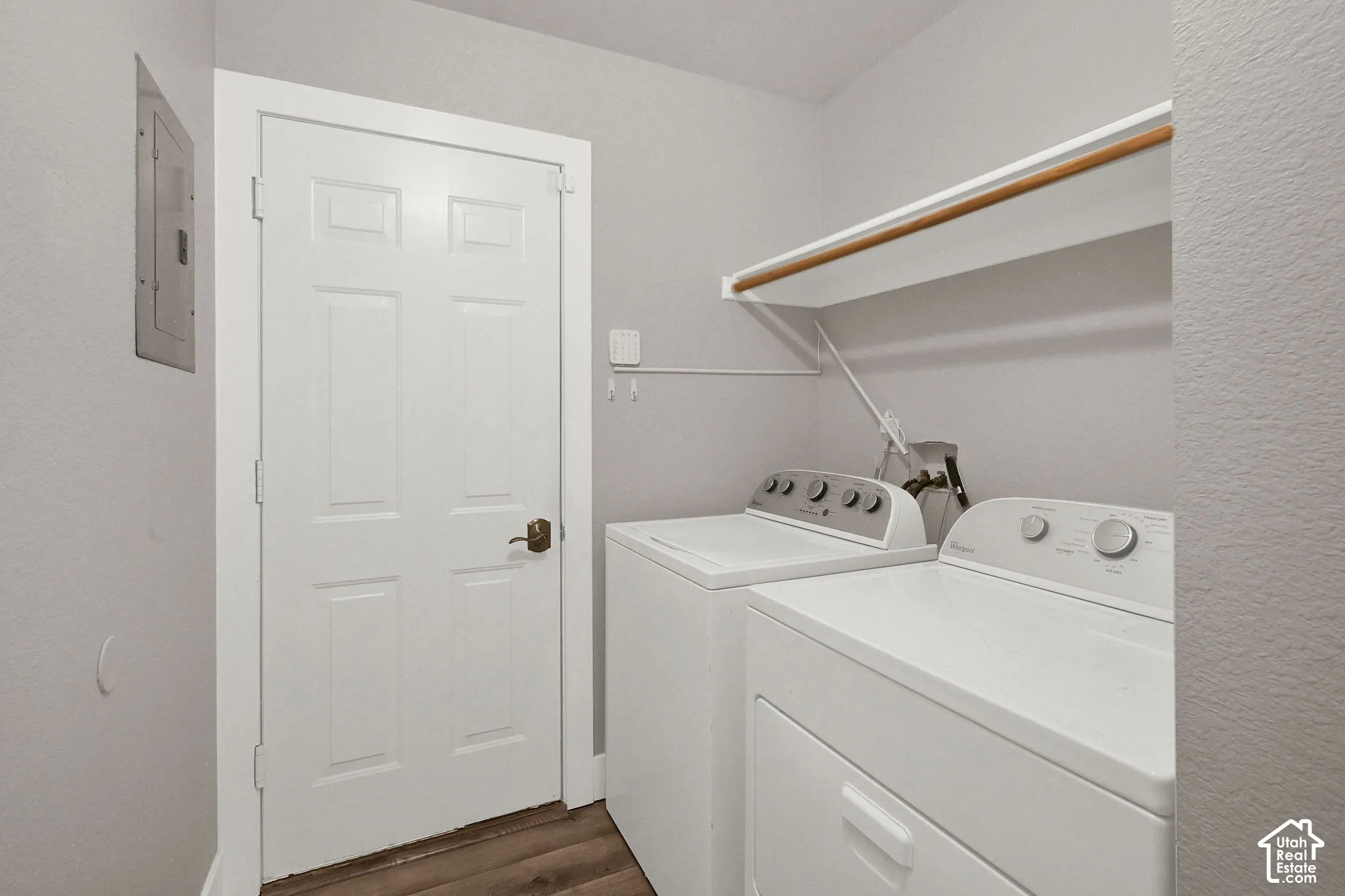 Wood-finish flooring with a white six-panel interior door