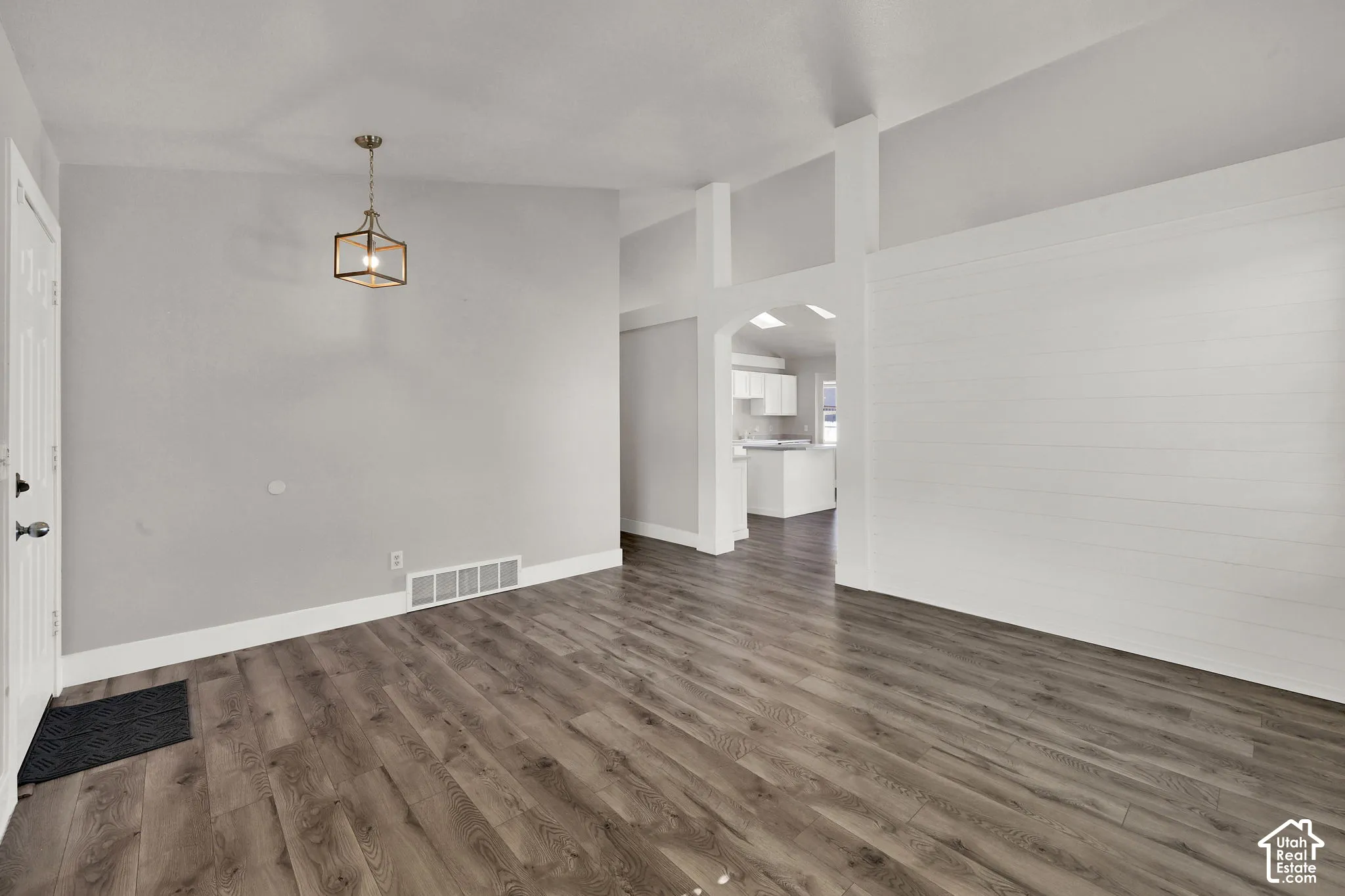 Wood-finish flooring, vaulted ceilings, and a contemporary ceiling light fixture