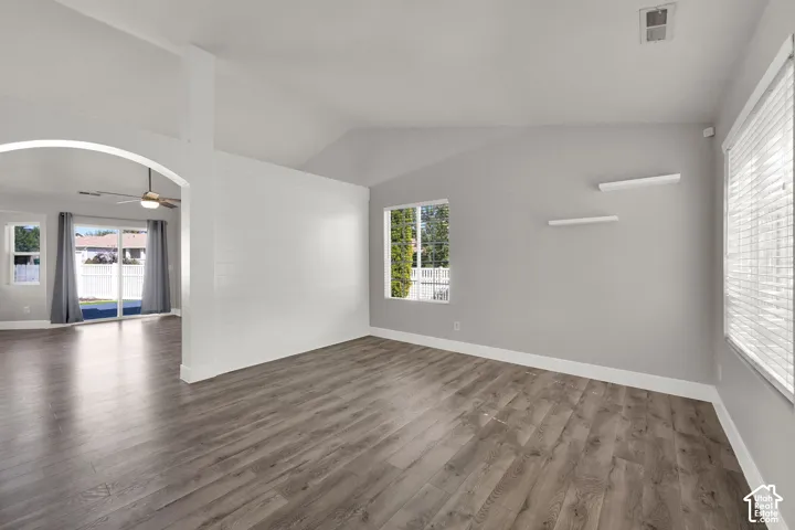 Wood-finish flooring throughout, vaulted ceiling, and an arched entry