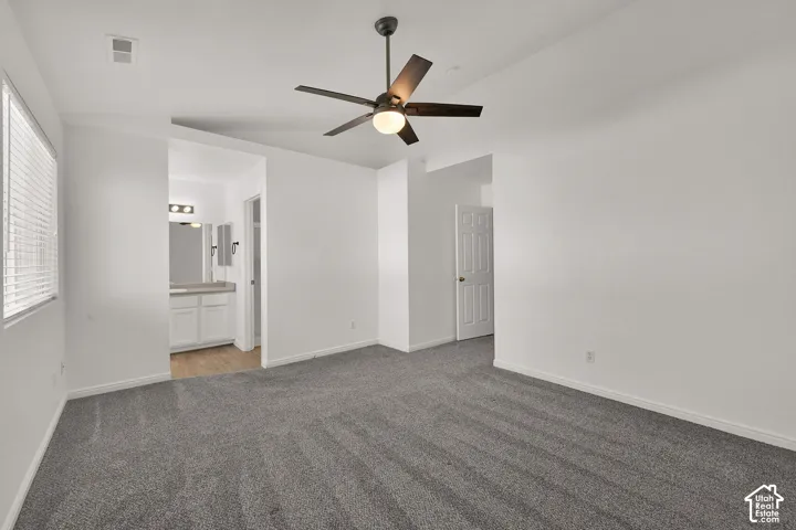 Spacious Primary Bedroom with gray carpeting and a ceiling fan